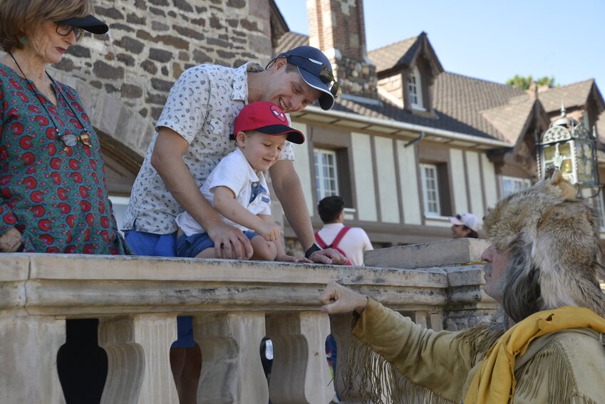 A little boy gives Buckskin Joe a fist bump on the front steps of the Highlands Ranch Mansion at Pioneer Days.